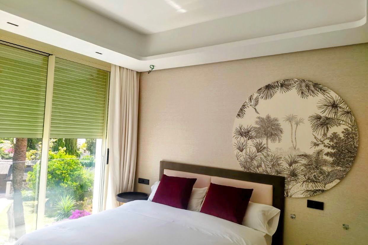 Dormitorio premium con falso techo de placas de yeso y papel pintado tropical decorativo en Marbella